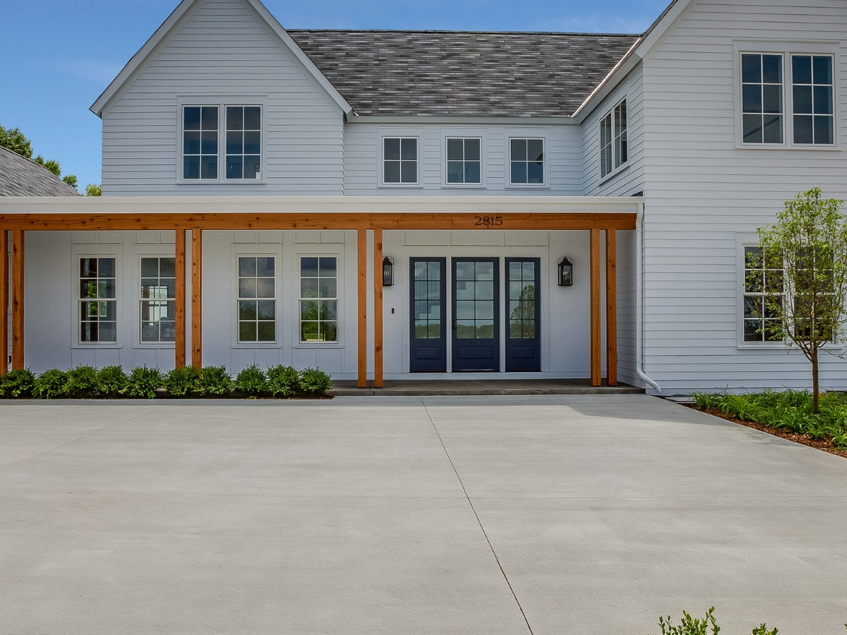 Residential driveway and porch cleaning, demonstrating removal of tough stains and restoration of entryway appearance.