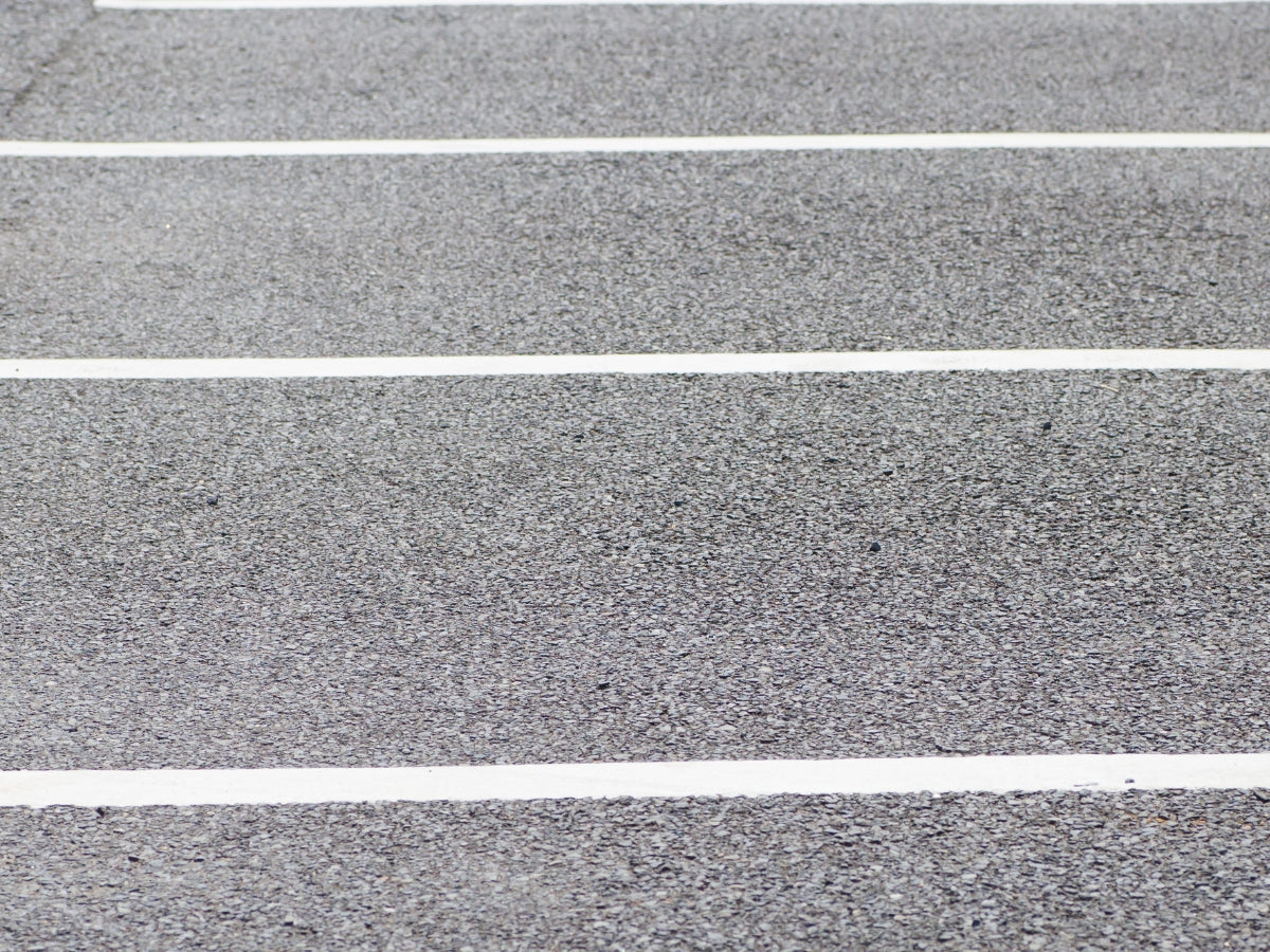 Commercial parking lot cleaning process with visible removal of oil stains and accumulated dirt, promoting a safer and cleaner parking environment.